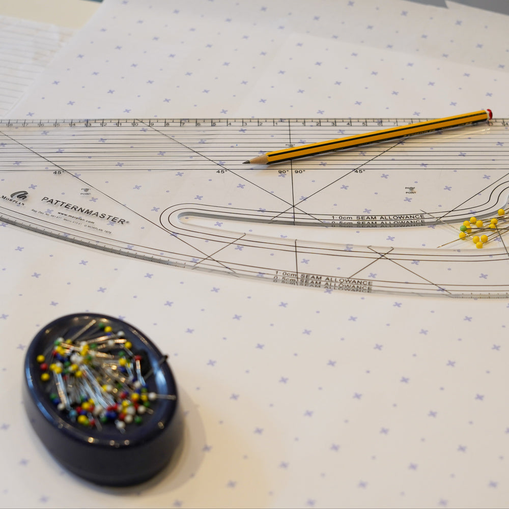 Pattern master ruler and pattern paper with pins and a ruler on a table