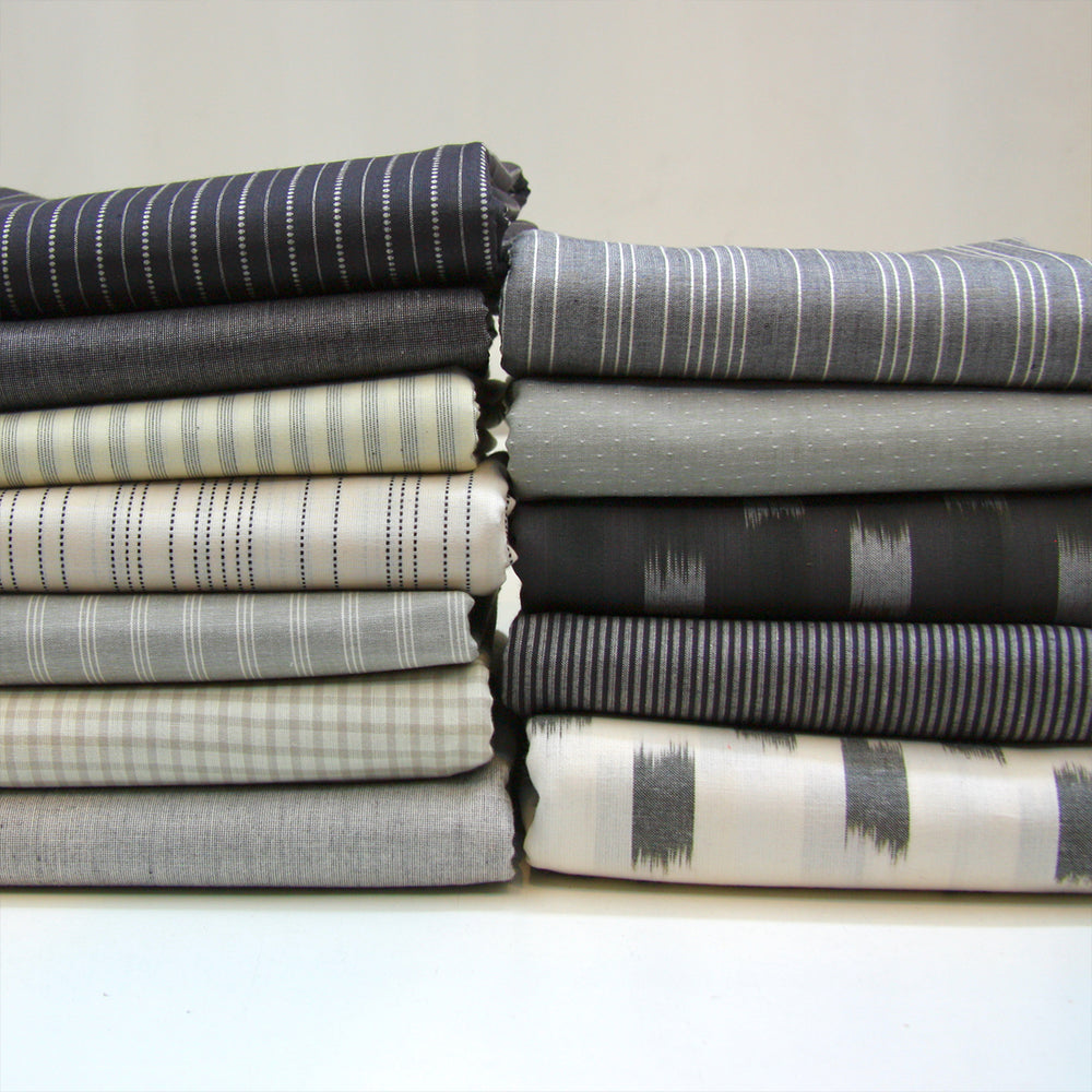 pile of folded grey and white woven fabrics