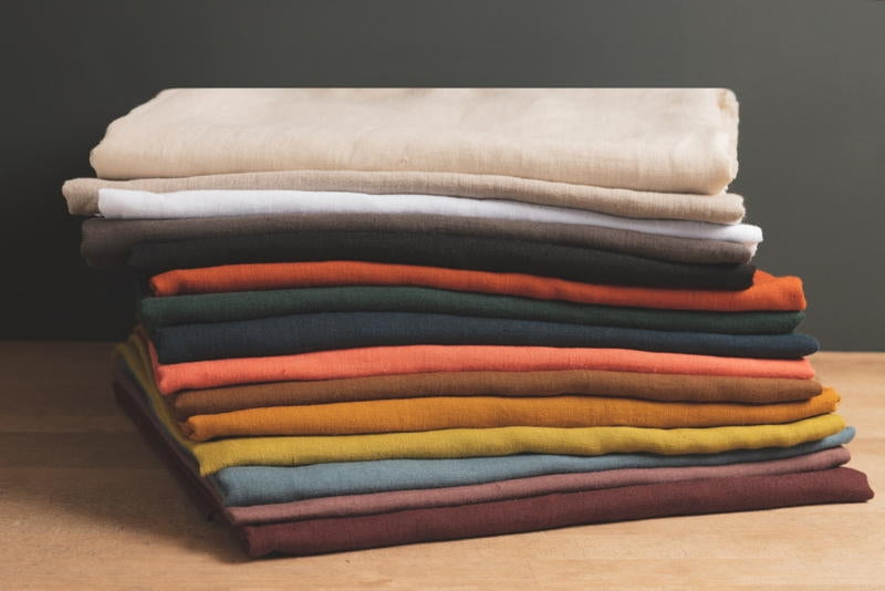 stack of coloured and washed european linen fabrics