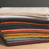 stack of coloured and washed european linen fabrics