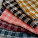 pile of folded fabric gingham linen colours