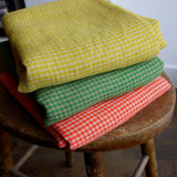 pile of folded yellow linen gingham fabric