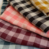 pile of folded fabric gingham linen colours