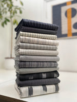 pile of folded grey and white woven fabric